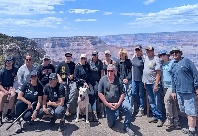 A big group of Rip to the Rim riders posing together at a Grand Canyon overlook